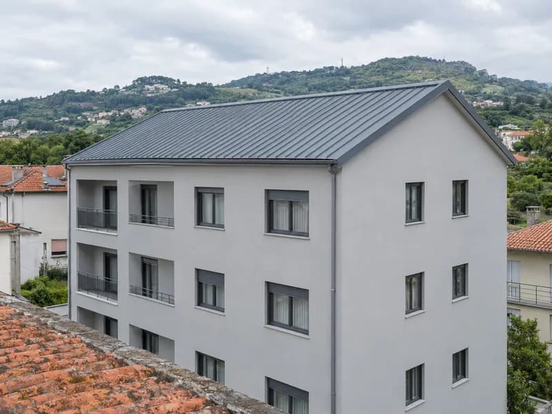 Cobertura nova em painel sandwich antracite num prédio de habitação